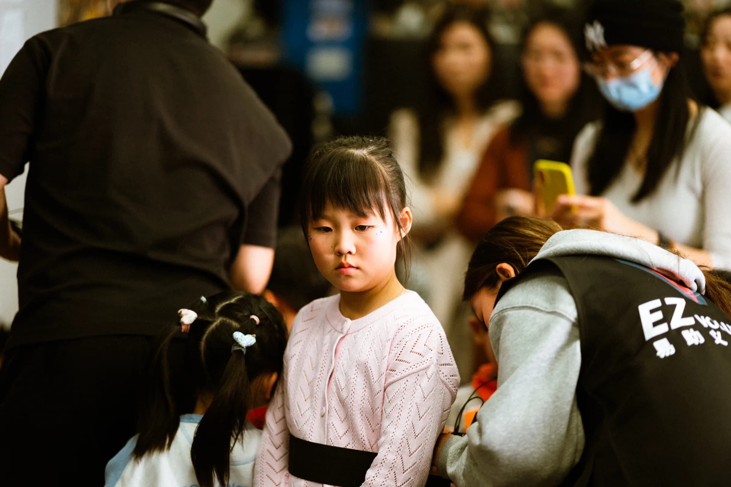 A young TADA performer concentrating while students prepare nearby.