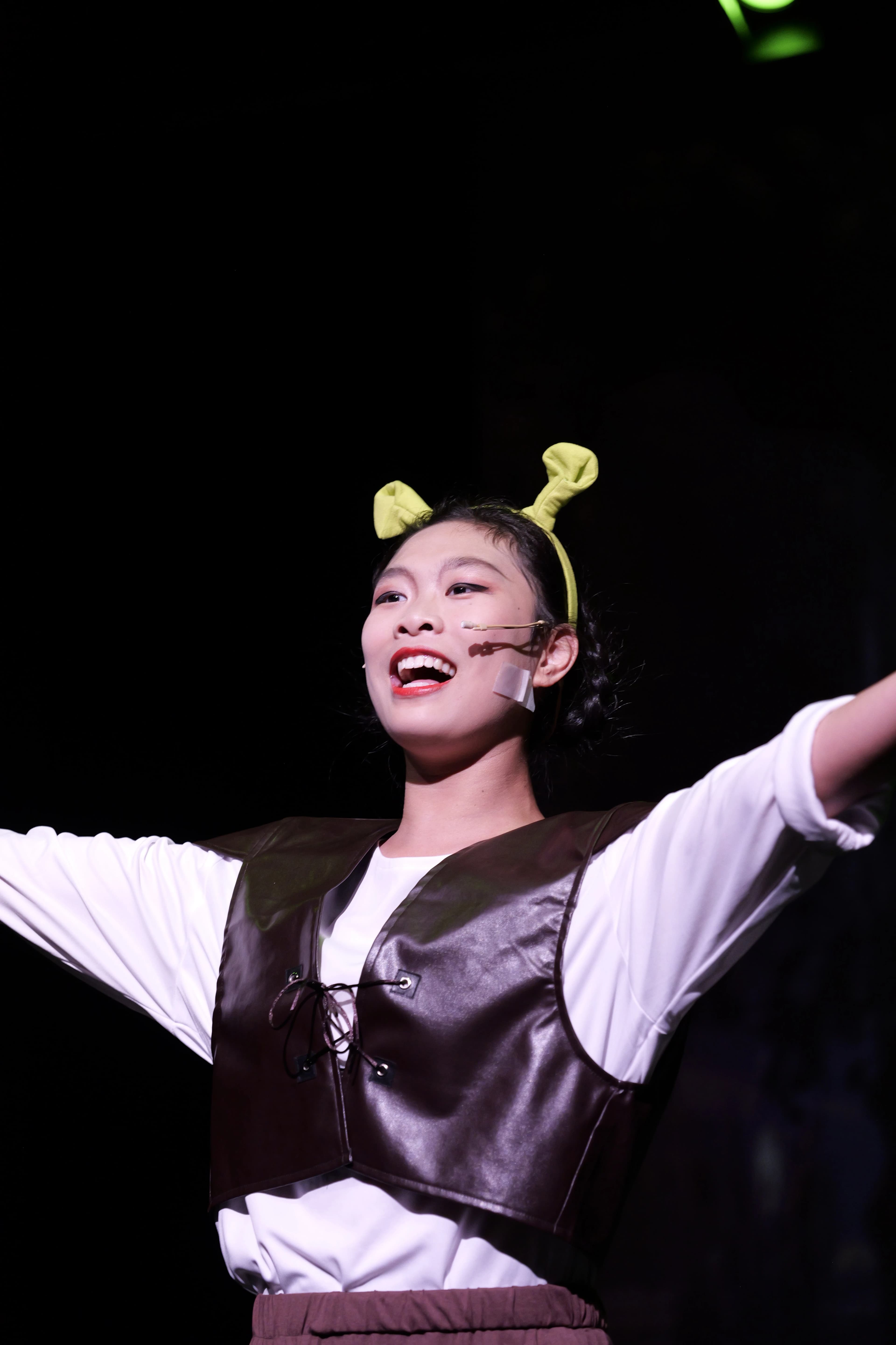 A TADA student singing onstage in an ogre costume